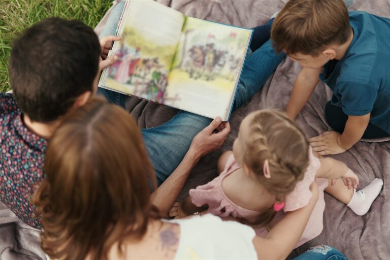 Família lendo um livro clássico infantil ao ar livre