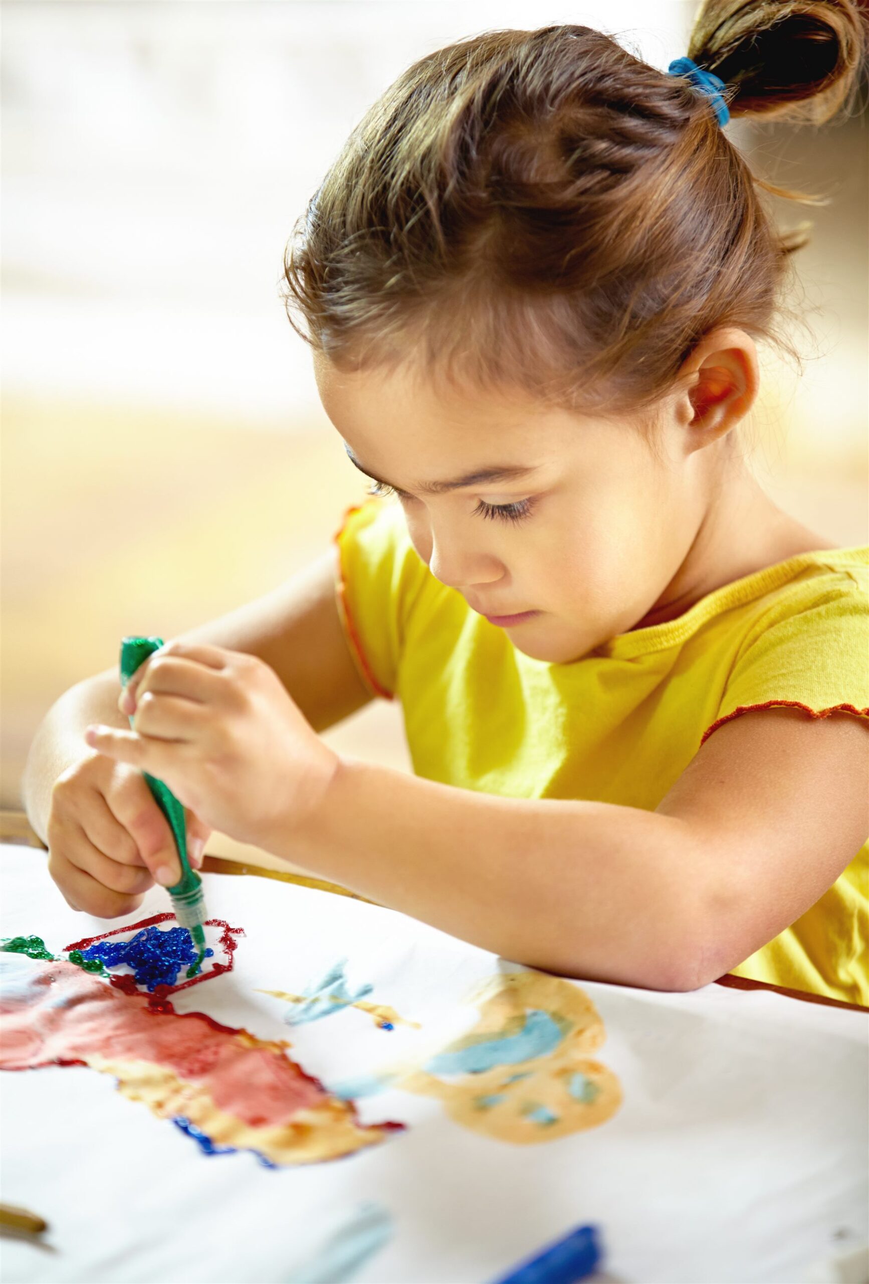 Criança pintando desenho colorido com tinta