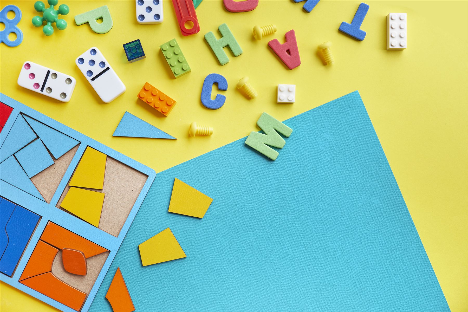 Brinquedos educativos coloridos: blocos, dominó e quebra-cabeça